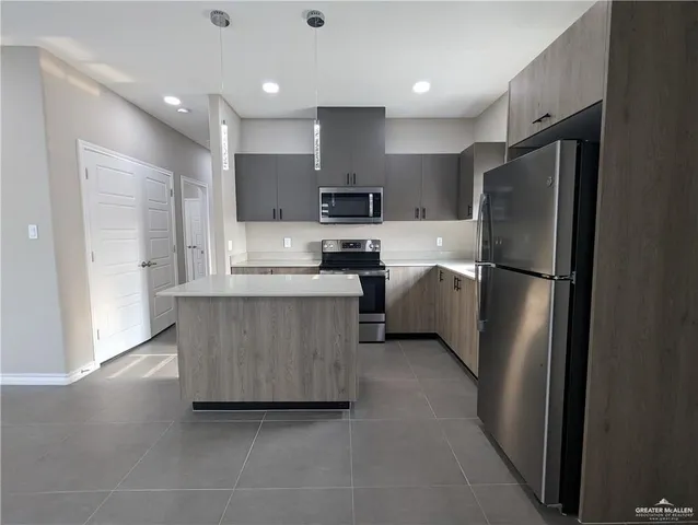 a kitchen with stainless steel appliances granite countertop a refrigerator a sink and a stove