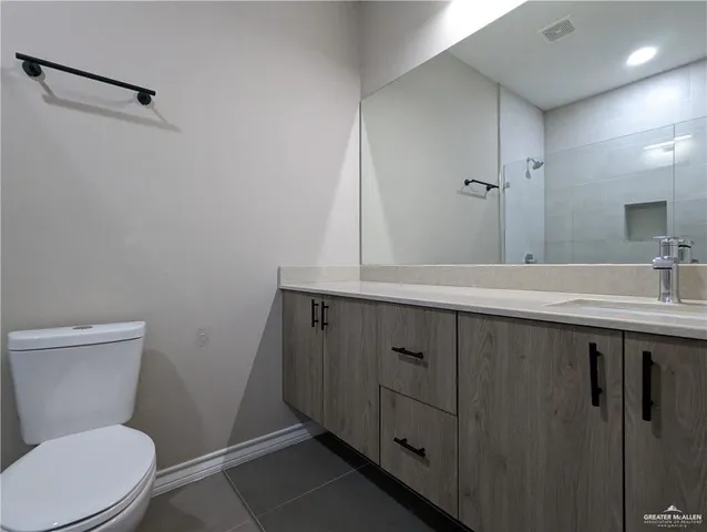 a bathroom with a sink a toilet a mirror and vanity