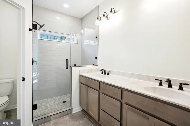 a bathroom with a double vanity sink mirror and shower