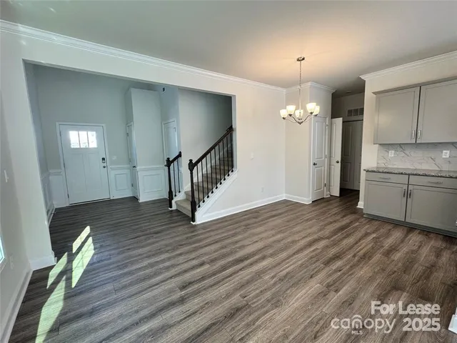a view of a kitchen with wooden floor and cabinets