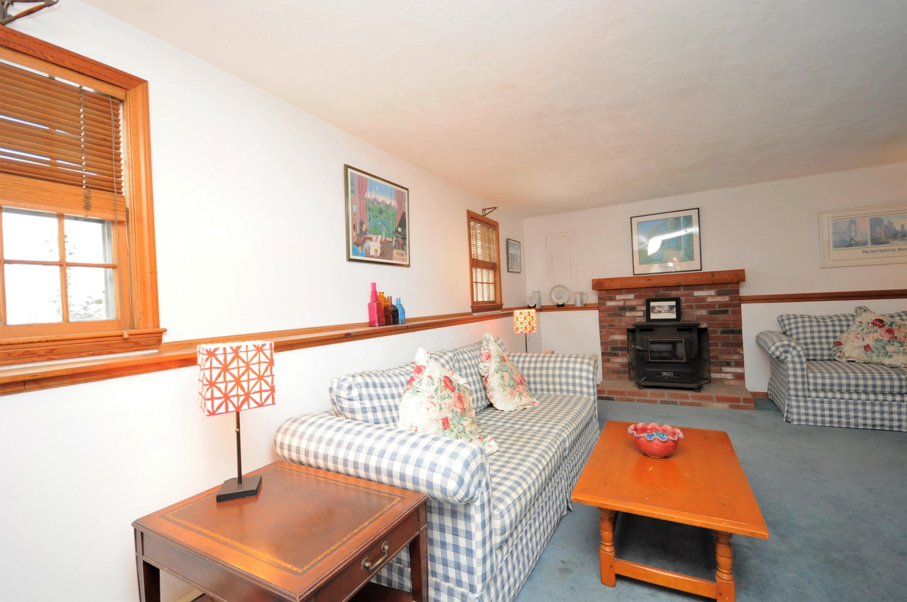 15 McGrath Road Sagamore Beach, MA 02562 - Photo 17 of 24 a living room with furniture a flat screen tv and a fireplace