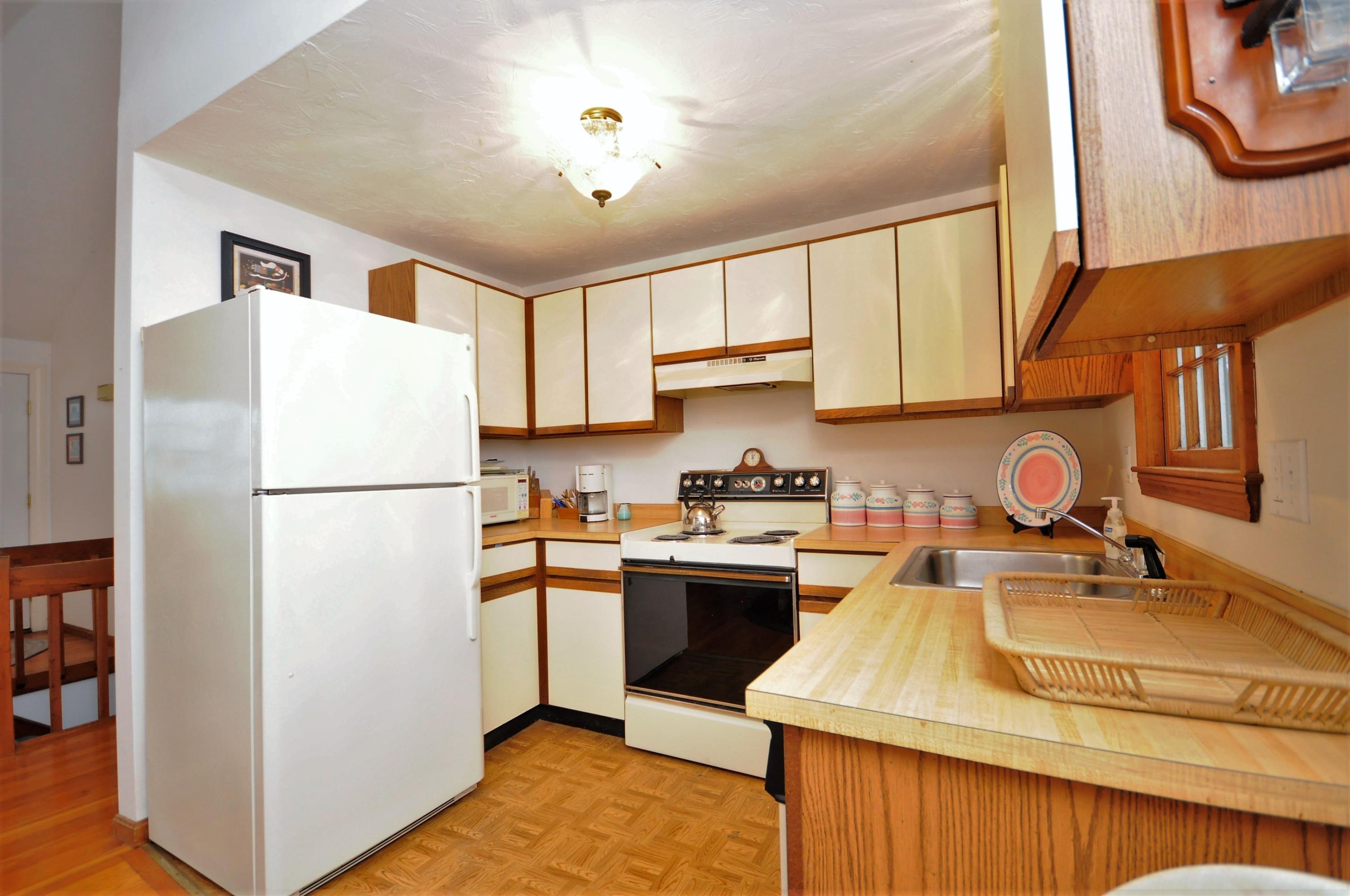 15 McGrath Road Sagamore Beach, MA 02562 - Photo 8 of 24 a kitchen with stainless steel appliances granite countertop a sink stove and refrigerator