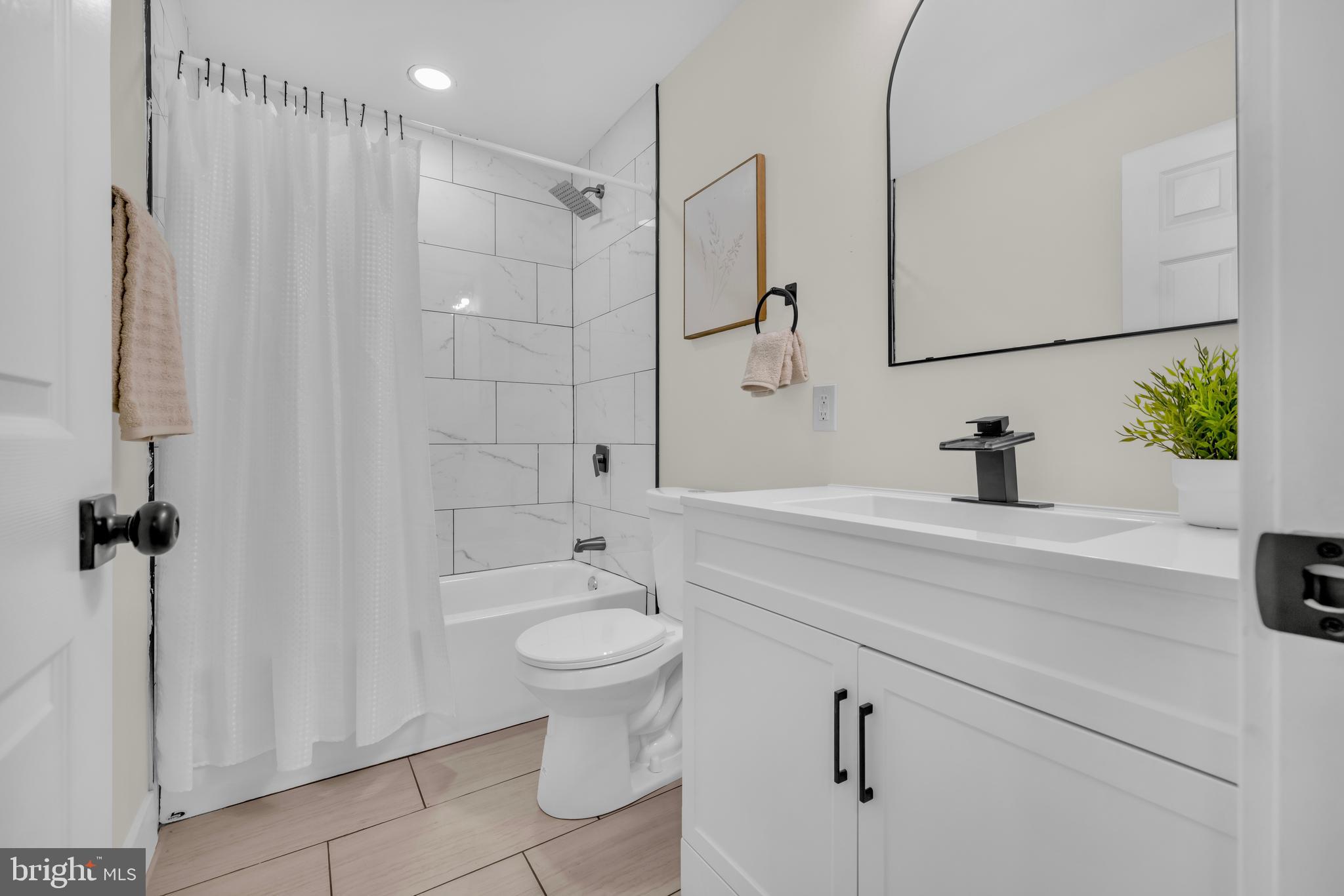 3827 Cottage Avenue Baltimore, MD 21215 - Photo 14 of 43 a bathroom with a sink a toilet a mirror and shower