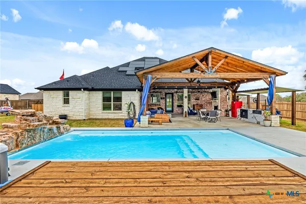 a view of a swimming pool with sitting area in front of it