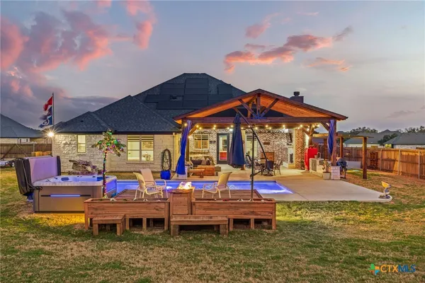 a view of a swimming pool with a table and chairs under an umbrella