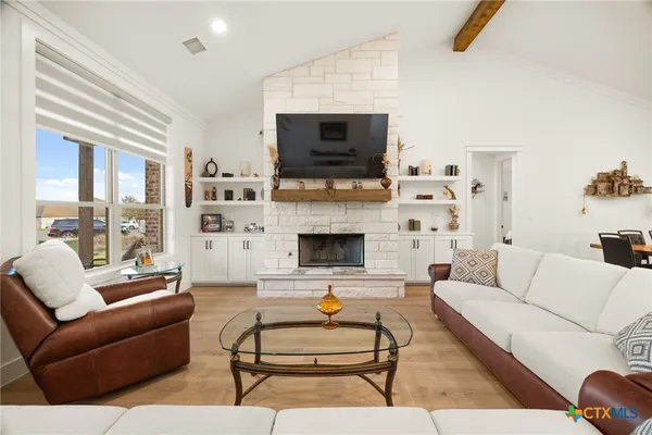 a living room with furniture a flat screen tv and a fireplace