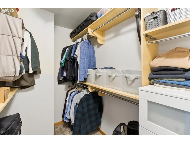 a view of walk in closet with clothes and shoes