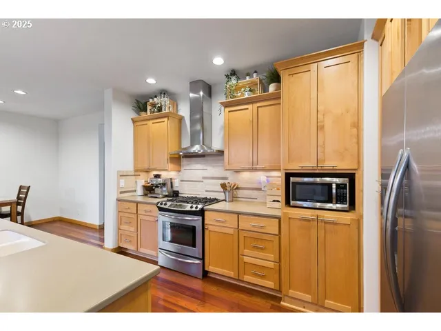 a kitchen with stainless steel appliances granite countertop a stove a sink dishwasher and a refrigerator