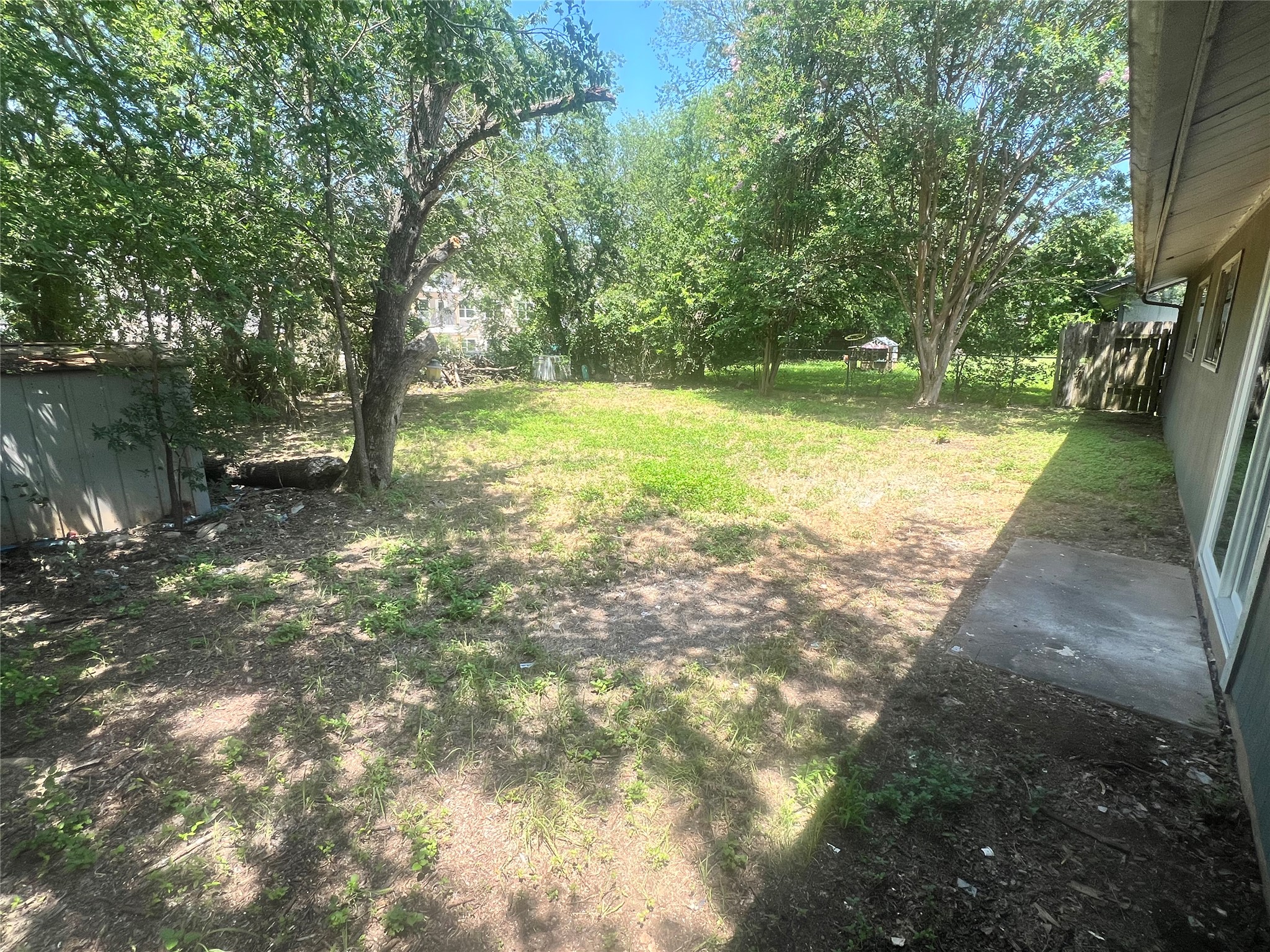 4620 Button Bend Road Austin, TX 78744 - Photo 22 of 22 A spacious backyard with mature trees offers a private, shaded retreat.