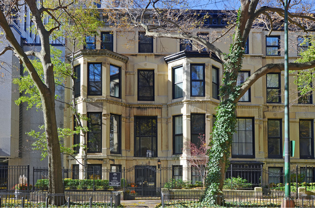a front view of a multi story residential apartment building with a yard and balcony
