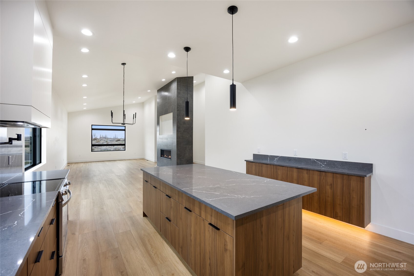 501 Sand Dune Road Moses Lake, WA 98837 - Photo 8 of 38 a kitchen with stainless steel appliances a kitchen island a stove and a wooden floors