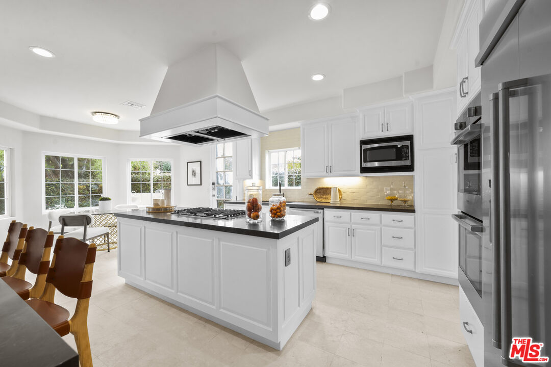 7861 West 80th Street Playa del Rey, CA 90293 - Photo 9 of 42 a kitchen with stainless steel appliances kitchen island granite countertop a sink and cabinets