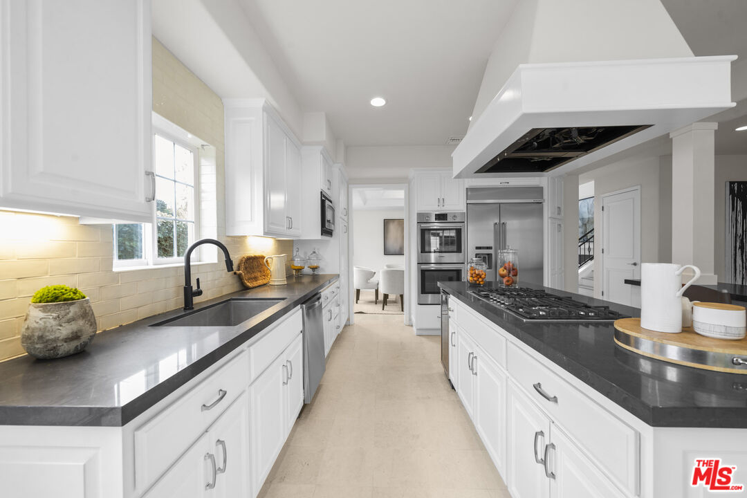 7861 West 80th Street Playa del Rey, CA 90293 - Photo 10 of 42 a large kitchen with granite countertop a sink and cabinets