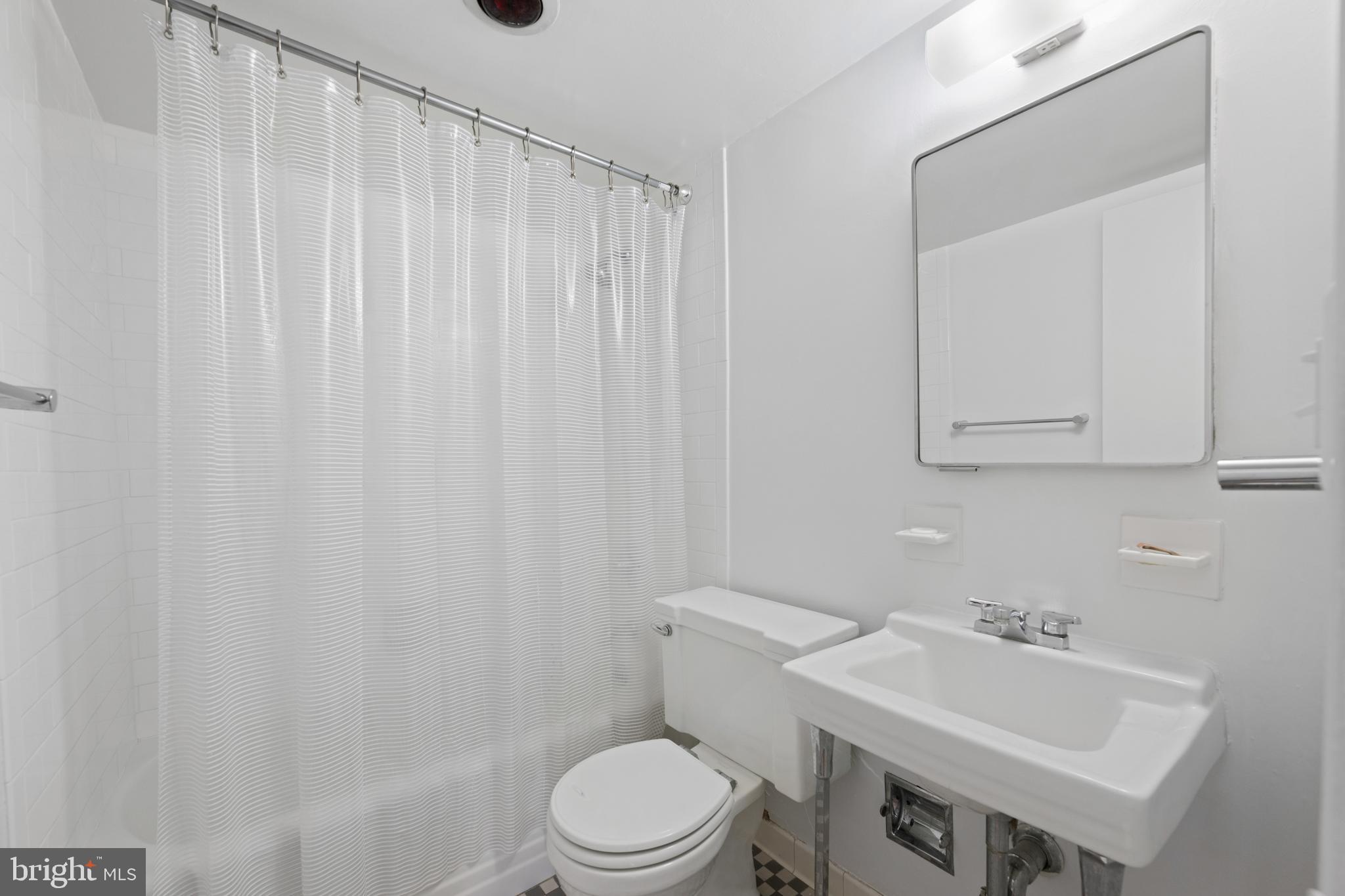 200 Locust Street, Unit 10GN Philadelphia, PA 19106 - Photo 16 of 28 a bathroom with a sink a toilet and shower curtain
