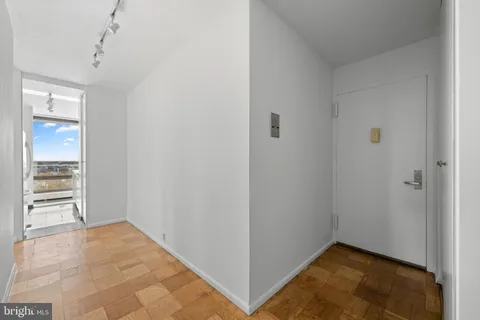 a view of an empty room with closet and cabinet