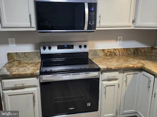 a kitchen with stainless steel appliances granite countertop a stove top oven a sink dishwasher and a refrigerator