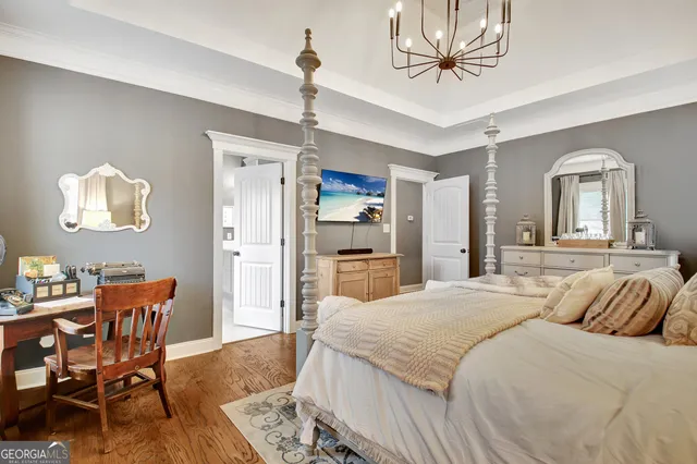 a spacious bedroom with a bed a table and chair