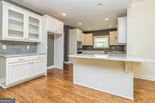 a large kitchen with stainless steel appliances granite countertop a stove a sink and a refrigerator