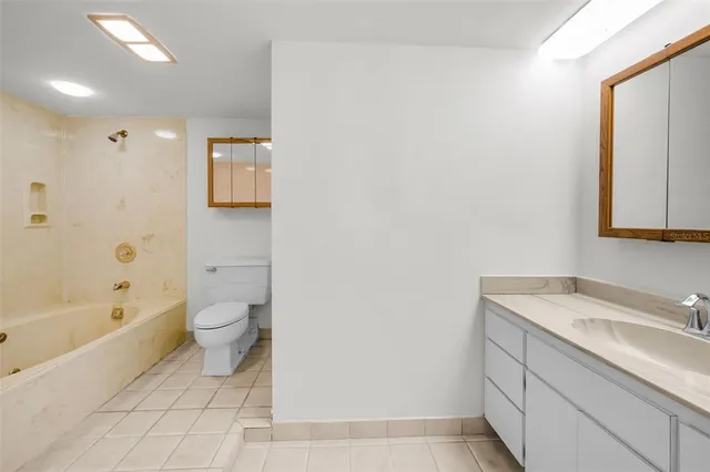 a view of an empty room with wooden floor and a ceiling fan