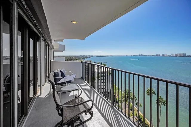 a balcony with chairs and wooden fence