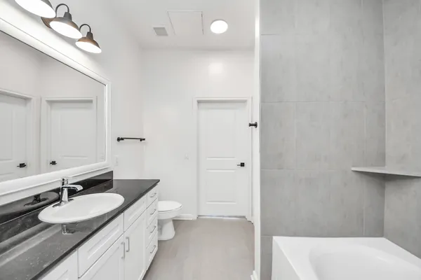 a bathroom with a tub sink double mirror and a shower