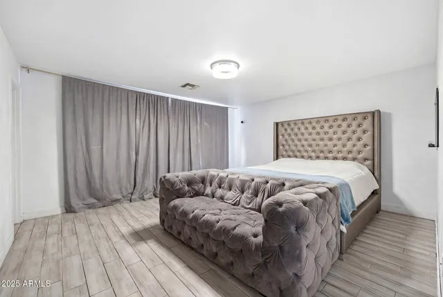 a bedroom with a bed and a wooden floor