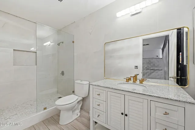 a spacious bathroom with a granite countertop sink a toilet and shower