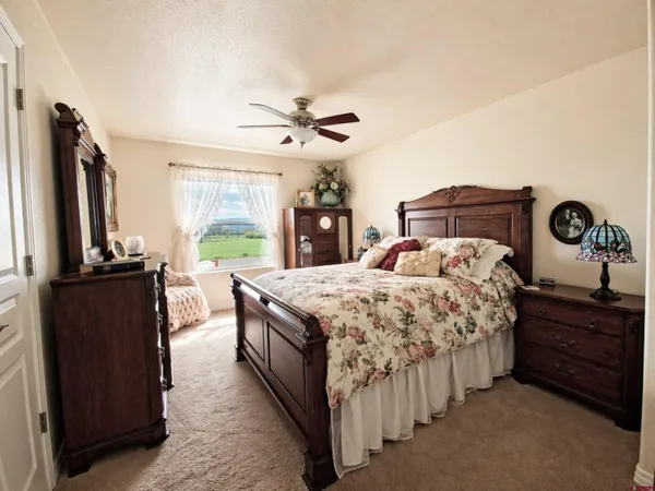 a bedroom with a bed and a flat tv screen on dresser