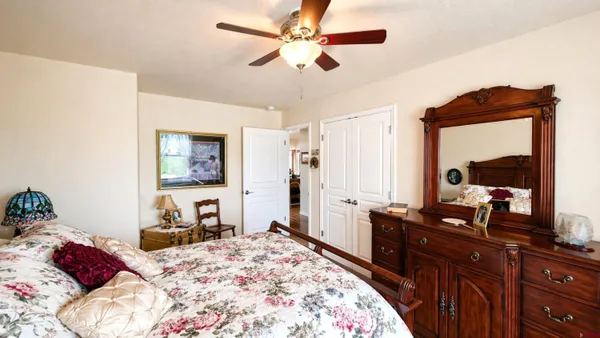 a bedroom with a bed and a dresser with mirror