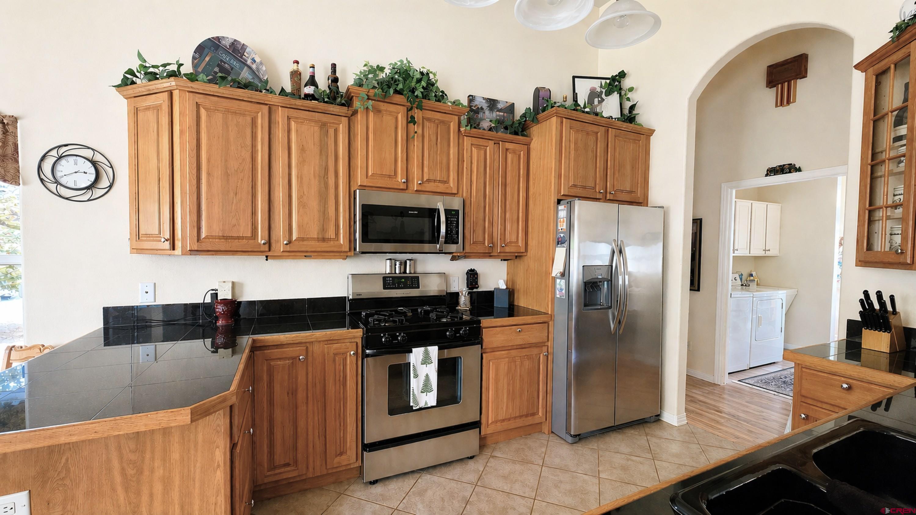 2357 5500th Road Delta, CO 81416 - Photo 6 of 37 a kitchen with granite countertop a refrigerator a stove and a sink with wooden floor