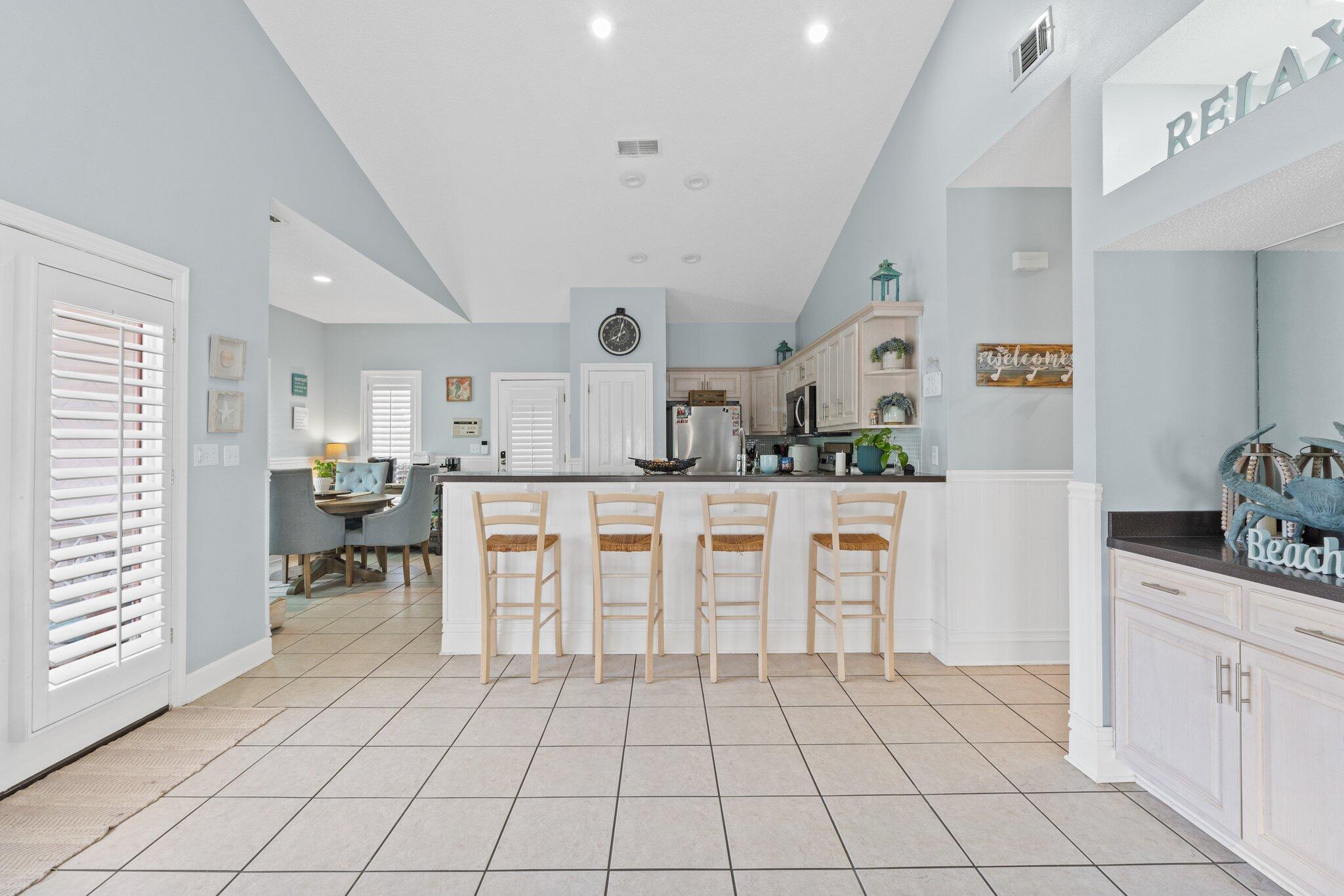 4460 Ocean View Drive Destin, FL 32541 - Photo 15 of 53 a kitchen with white cabinets and chairs