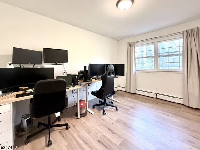 a view of a workspace with furniture and a window