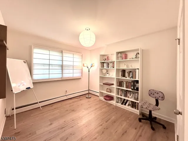 a view of a room with gym equipment and wooden floor