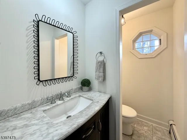 a bathroom with a granite countertop toilet a sink and a mirror