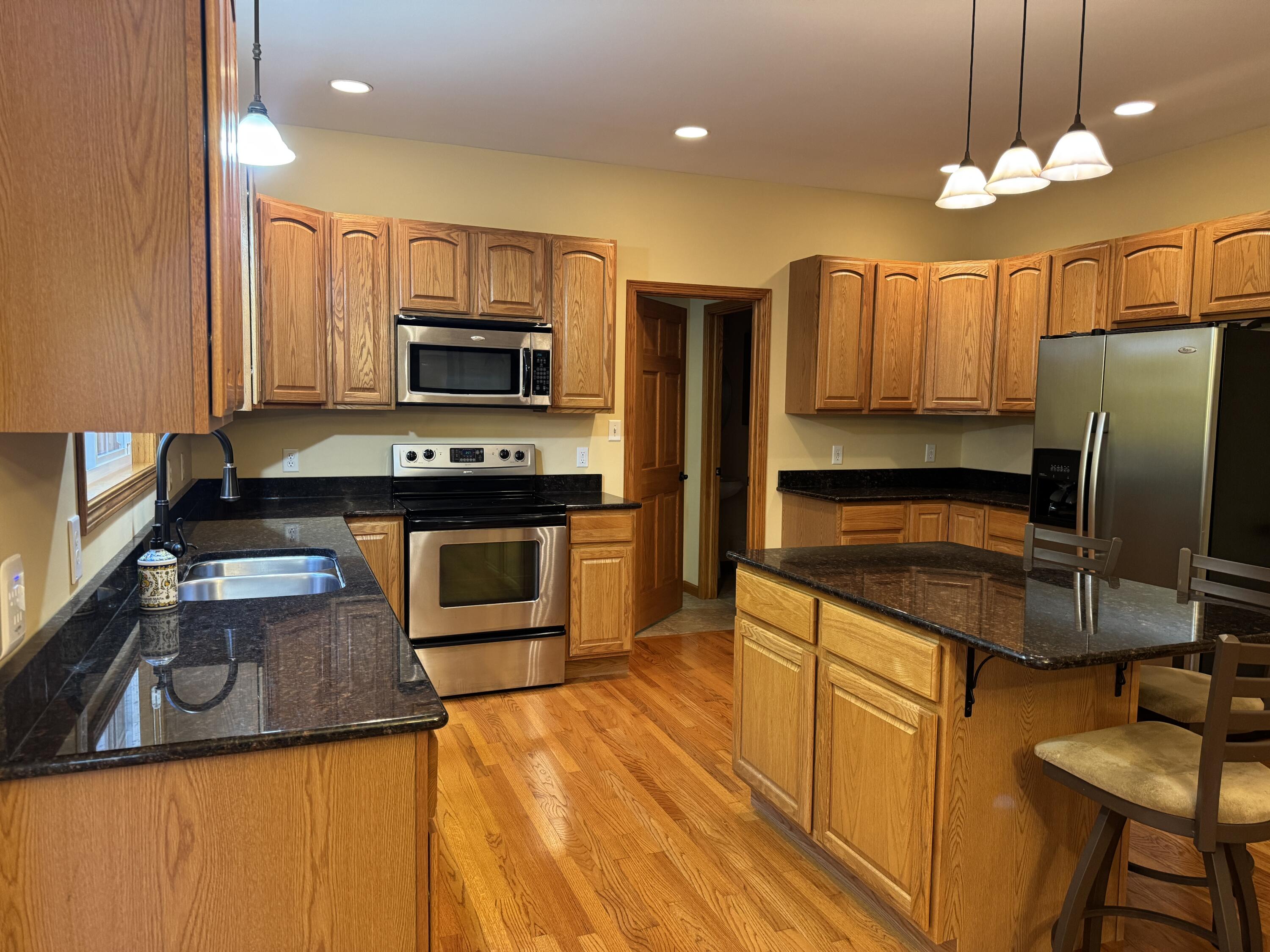 1521 Birdie Way Chesterton, IN 46304 - Photo 17 of 58 a kitchen with stainless steel appliances granite countertop a sink stove and refrigerator