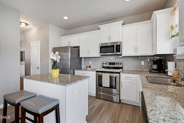 a kitchen with stainless steel appliances granite countertop a refrigerator stove microwave and sink