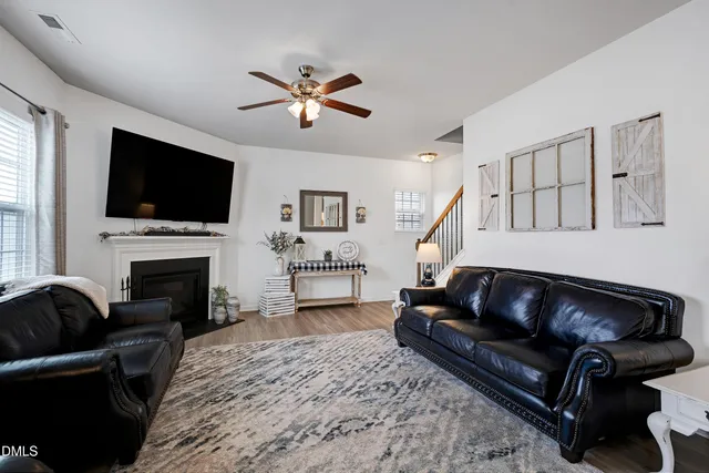a living room with furniture a fireplace and a flat screen tv