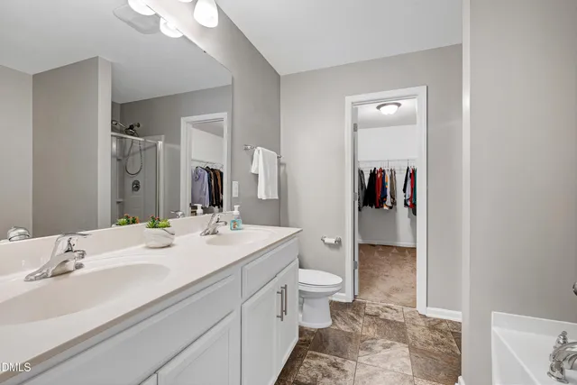 a bathroom with a sink and mirror with toilet