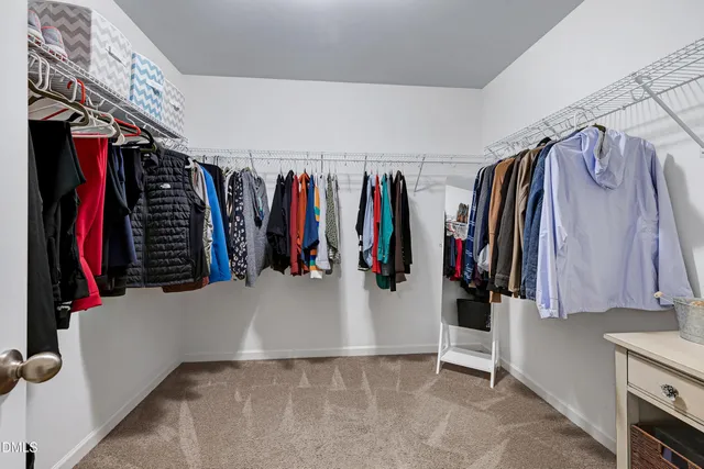 a view of walk in closet with clothes