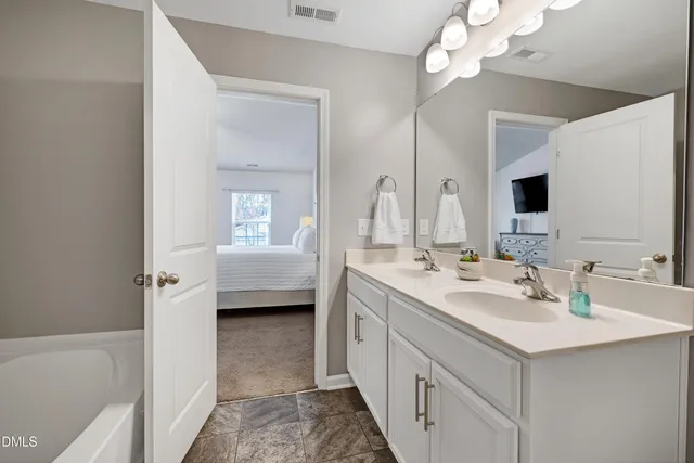 a bathroom with a sink a tub and a mirror
