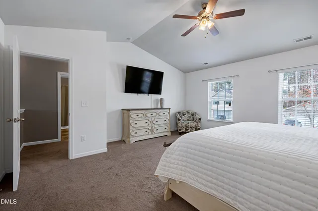 a spacious bedroom with a bed and a flat screen tv