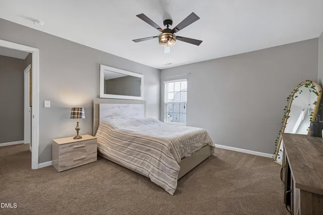 a bedroom with a bed and a ceiling fan