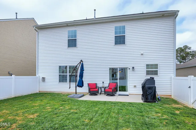 a view of a house with a backyard and a chair