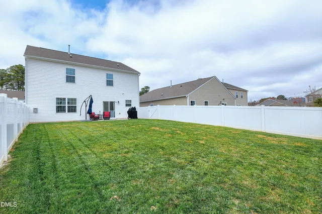 a backyard of a house with table and chairs