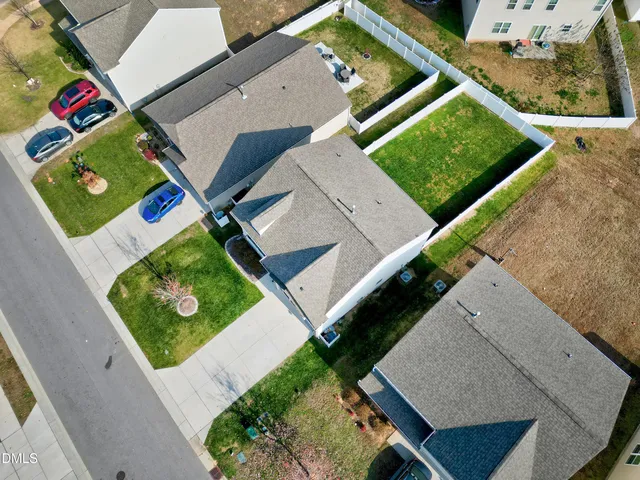 an aerial view of a house with a yard and street