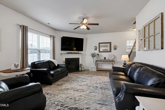 a living room with furniture a fireplace and a flat screen tv