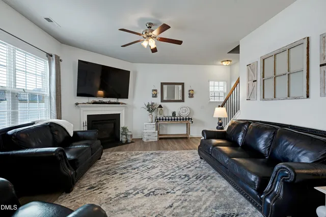 a living room with furniture a fireplace and a flat screen tv