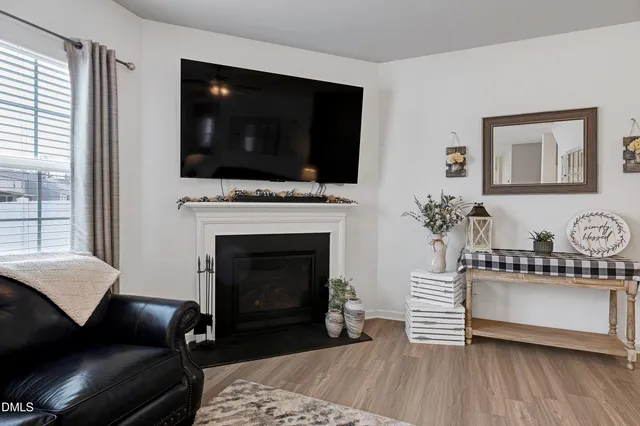 a living room with furniture a flat screen tv and a fireplace