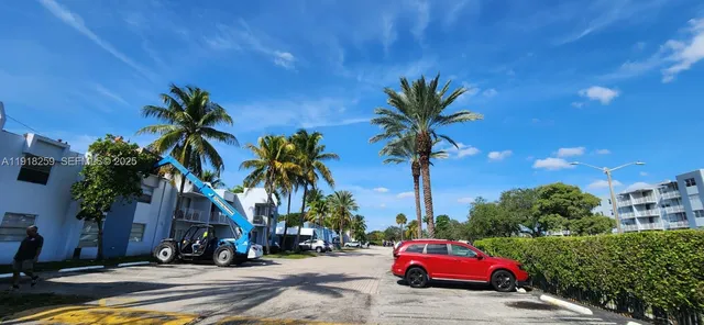 a car parked in front of a house with palm trees