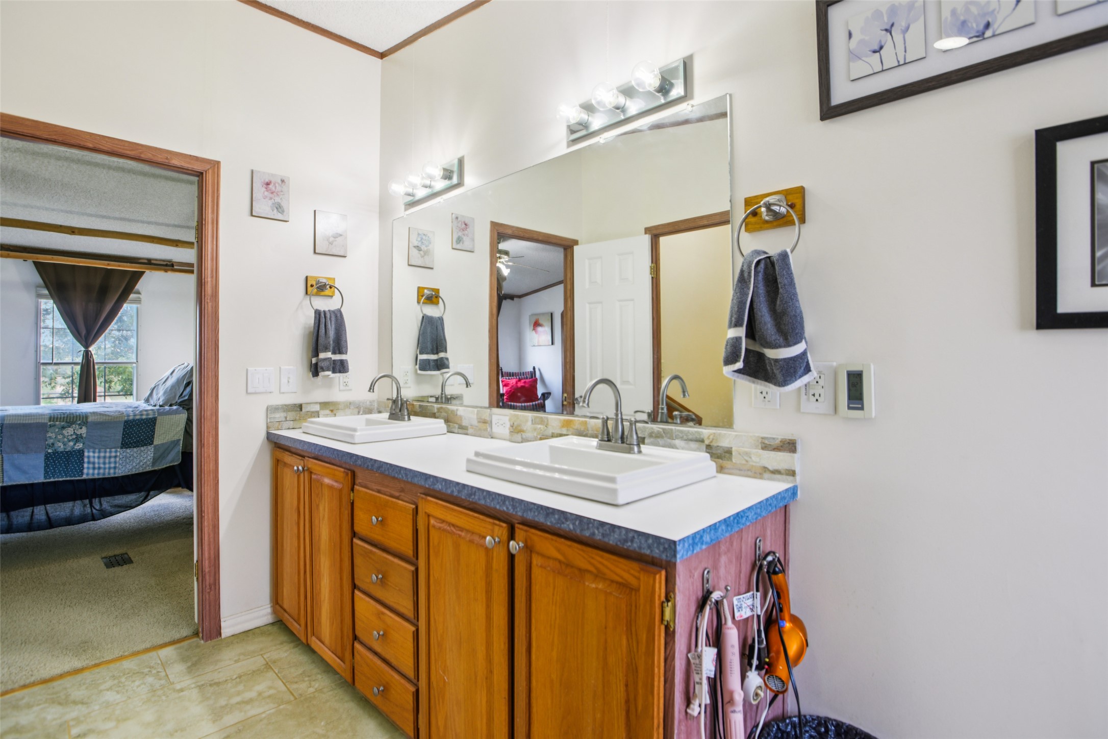 372 Hofferek Road Rosanky, TX 78953 - Photo 16 of 40 Full bath with connected bathroom, double vanity, and light tile patterned floors